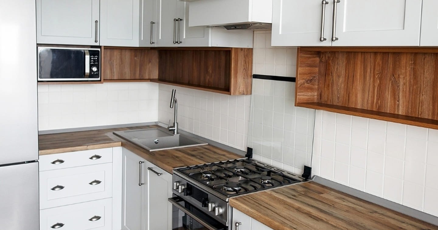 L-shaped kitchen renovation Rowville - white Shaker cabinets, solid timber benchtops, gas cooktop, subway tile splashback and timber flooring