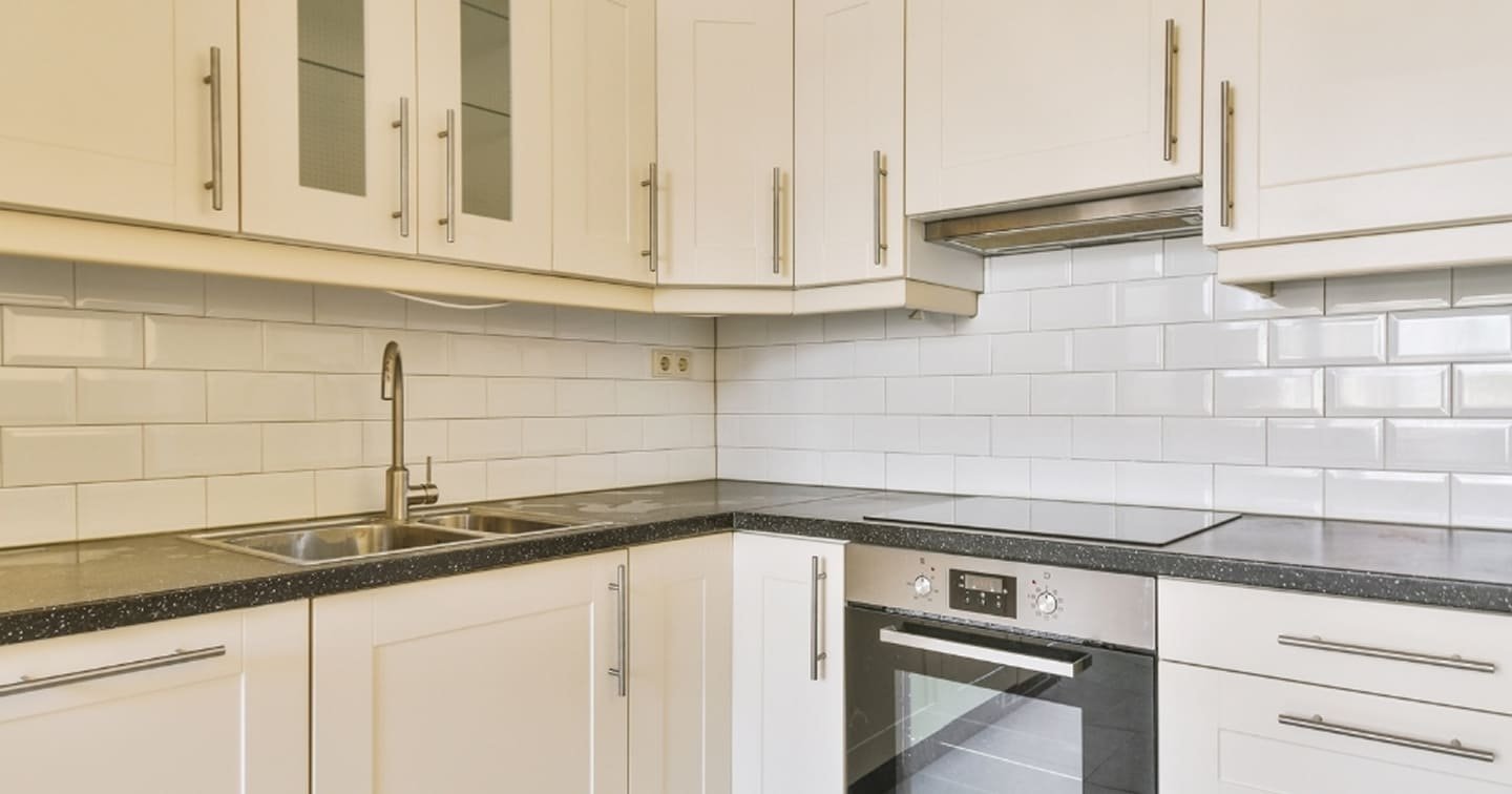 Classic white kitchen renovation Mitcham - Shaker cabinets with glass display doors, subway tile splashback and dark reconstituted stone benchtops