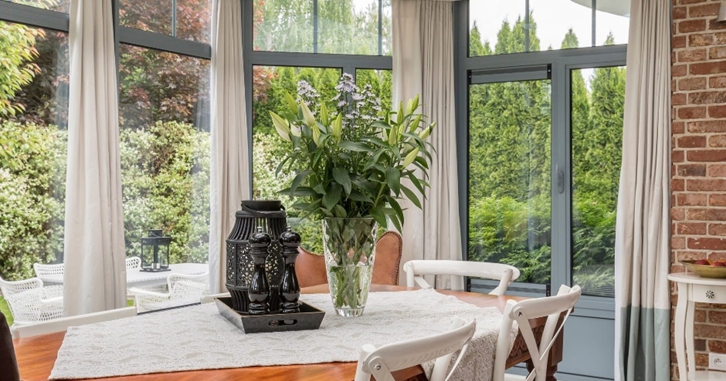 Dining room extension Vermont - floor-to-ceiling aluminium windows, exposed brick feature wall, timber dining table and garden views