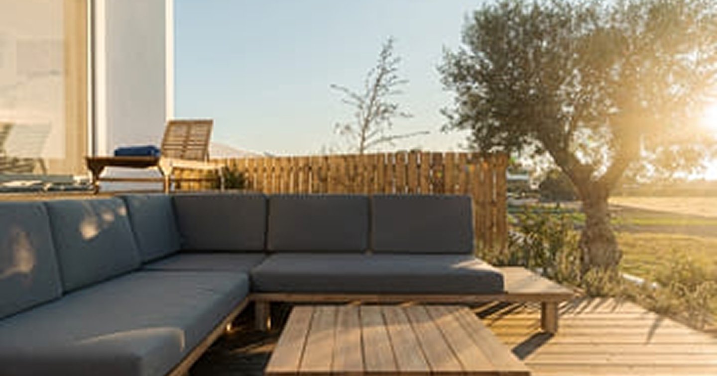 Outdoor lounge deck The Basin - L-shaped built-in sofa with cushions, hardwood timber deck, coffee table and privacy fence at sunset
